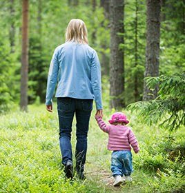 Woman and daughter on a walk through the forest (photo)